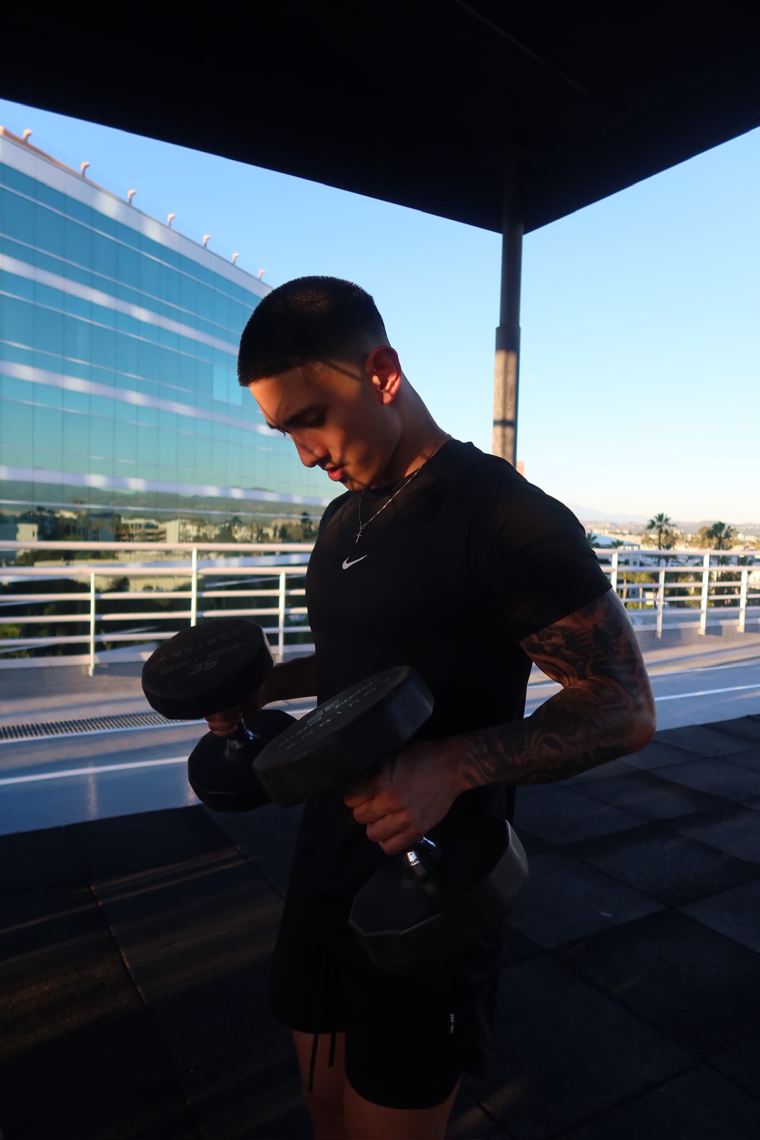 Cristian Santo Domingo, Orange County personal trainer, performing barbell curls in the gym.
